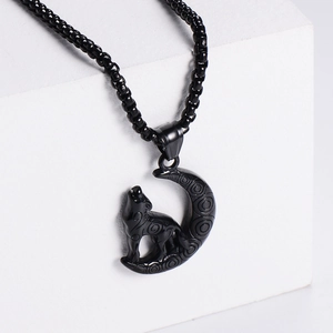 Viking wolf moon pendant necklace in black stainless steel on white stone display
