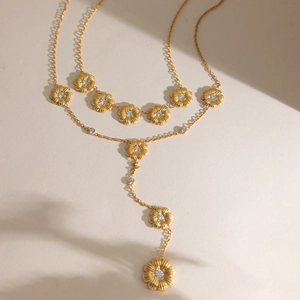 Collier marguerite dorée avec zircon blanc et chaîne délicate sous une vue de lumière chic