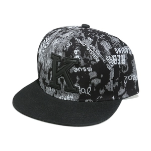 Close-up of hip-hop flat brim hat with K-letter patch and graffiti pattern