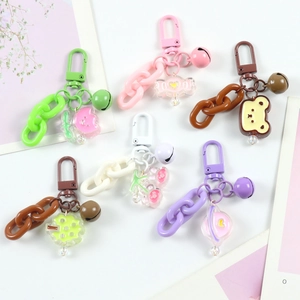 Close-up of colorful cartoon keychains with matching chains, bells and bear charms