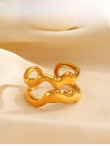 Detail of gold double-layer wave ring on beige satin fabric showing polished texture