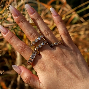 Detail shot of four gold-plated stainless steel rings with heart and pear zircon stones