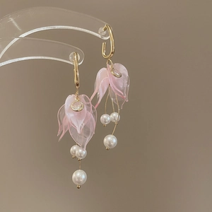 Detail of pink petal earrings with white pearl tassels and golden hooks for women