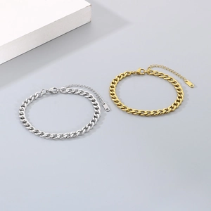 Detail of silver and gold stainless steel Cuban link anklets with lobster clasps