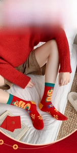 Detail of red combed cotton crew socks with dragon pattern and festive motifs