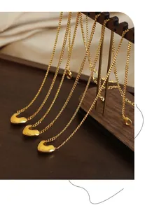 Vue détaillée du collier avec pendentif cœur doré sur un support en bois élégant