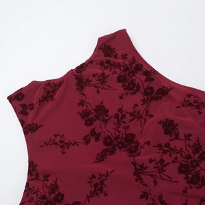 Close-up of deep red fabric featuring intricate black flocked floral pattern and texture