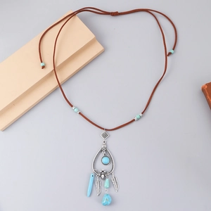 Detail of bohemian turquoise dreamcatcher necklace with silver feathers and beads