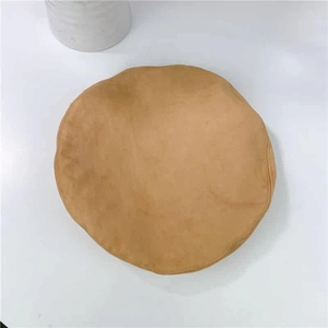 Top down shot of camel faux suede beret hat showing soft fabric and fine stitching detail