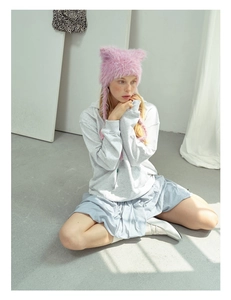 Detail of pink fuzzy cat ear hat featuring soft plush texture and long ear flaps