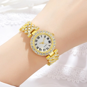 Detail of a gold women's quartz watch with sparkling rhinestones on lace background