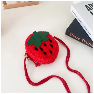 Detail of red plush strawberry crossbody bag with green leaves and woven shoulder strap