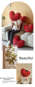 Detailed view of plush red heart-shaped pillow with Happy Home label on soft fabric