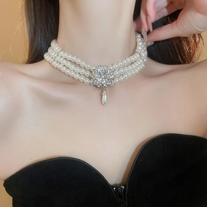 Detail of multi-layer pearl necklace with a diamond flower and water drop pendant