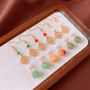 Vintage Chinese flower earrings with pearls and colorful beads on wooden tray