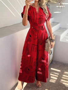 Detailed view of red floral jumpsuit with V-neck, wide legs, and waist button detail