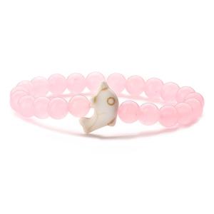 Detailed view of pink round beads with white ceramic dolphin pendant on elastic bracelet