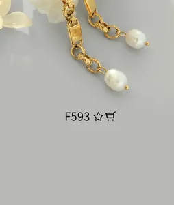 Close-up of gold pearl drop earring featuring intricate engraved metal texture and vintage design