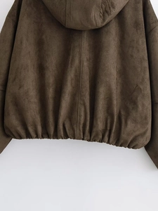 Detail of dark brown suede bomber jacket showing textured fabric and elasticated hemline