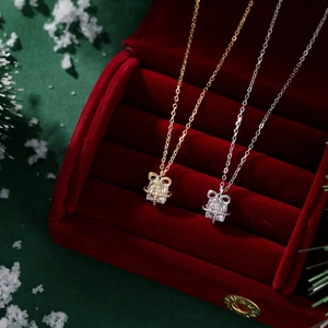 Exquisite bow gift box necklace in gold and silver finish inside a red velvet jewelry box