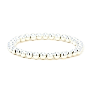 Detailed view of polished silver metal beads on a minimalist elastic bracelet strand