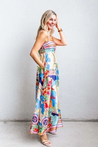 Detailed view of long satin summer dress with colorful tropical floral and ocean prints