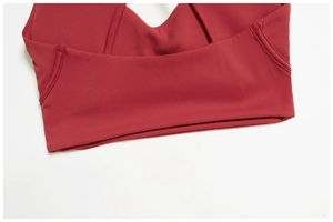 Detail van de brede zoom en versterkte zijnaden op de donkerrode sport bh