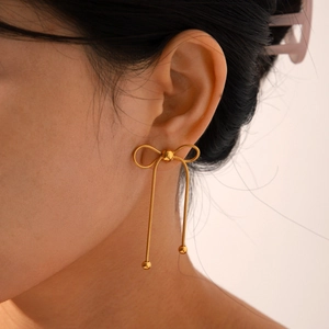 Macro shot of 18k gold butterfly earrings with long fringe and metal weave texture
