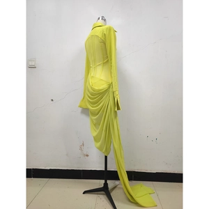 Detail of yellow sheer mesh dress showing the pleated waist and asymmetric hemline