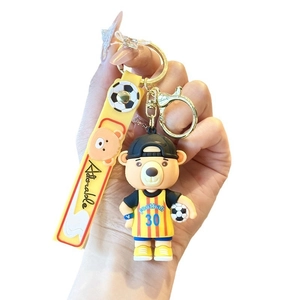 Cartoon football bear mascot keychain with blue jersey and yellow strap for keys