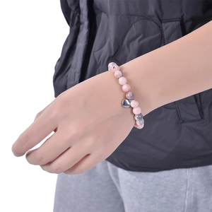 Pink zebra stone beaded bracelet with silver heart pendant worn on woman wrist