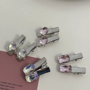 Close-up of pink and iridescent heart crystal hair clips with silver metal base