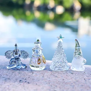 Set of 4 crystal glass figurines featuring an elephant, snowman, gnome, and Christmas tree