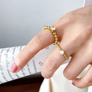 Detail of 18K gold plated bead ring and wavy band with sparkling cubic zirconia on hand