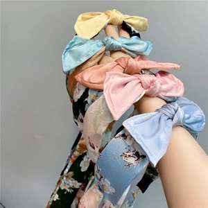 Detail of silk-texture bow headbands in yellow, blue and coral floral patterns