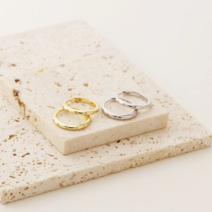Detail of s925 silver hoop earrings in gold and silver finish with pavé zircon stones