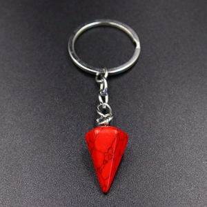 Detail of red marbled hexagonal stone pendant keychain with silver metal chain
