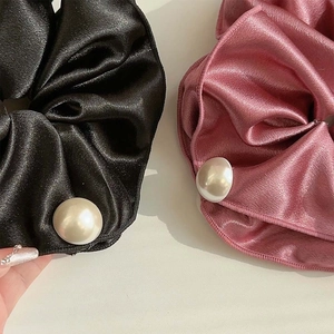 Set of two satin pearl scrunchies in black and pink with elegant glossy texture