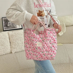 Vue détaillée du sac cabas matelassé rose à fleurs avec poignées et bandoulière longue