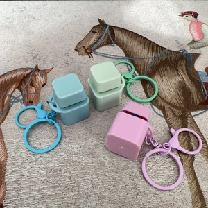 Close-up of three colorful silicone keycaps in blue, green, and pink with matching keychains