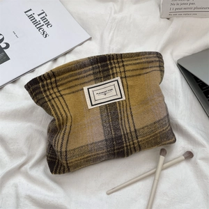 Detail of yellow and purple plaid makeup bag with Pleasant Time fabric label