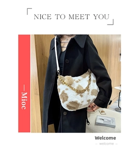 Detail of faux fur cow print tote bag with gold chain strap and leather handle
