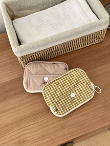 Close-up of quilted cherry embroidery and yellow plaid coin purses on a wooden table