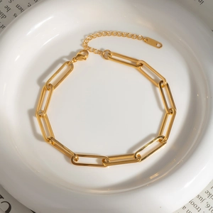 Elegant gold-plated stainless steel paperclip chain bracelet on white ceramic tray
