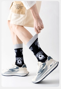 Detailansicht schwarzer Crew-Socken mit gestrickten Schnauzer-Hundemustern auf Baumwollstoff