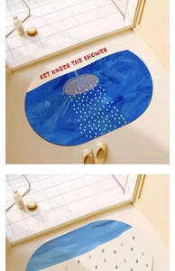 Detail view of oval blue absorbent bath mat with shower graphic and text in a bathroom