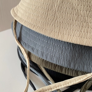 Detail of stacked water-ripple texture sun hats with adjustable drawstrings in varied colors