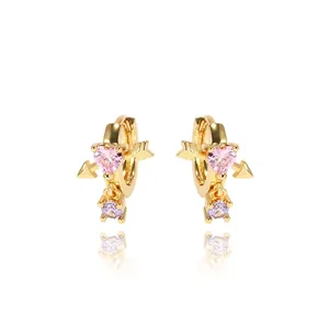 Golden heart arrow earrings with pink zircon stone and purple drop on white background
