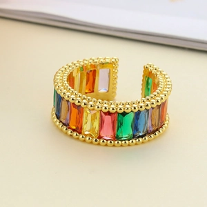 Macro detail of adjustable gold ring with rainbow baguette zircon and beaded edges