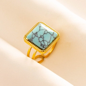 Macro view of adjustable golden steel ring with square turquoise stone and beaded trim